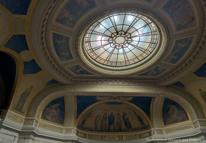 Domed ceiling featuring skylight and murals around it