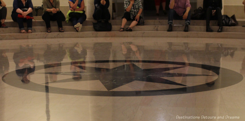 Light-coloured marble floor with a black star enclosed in a black circle at the centre