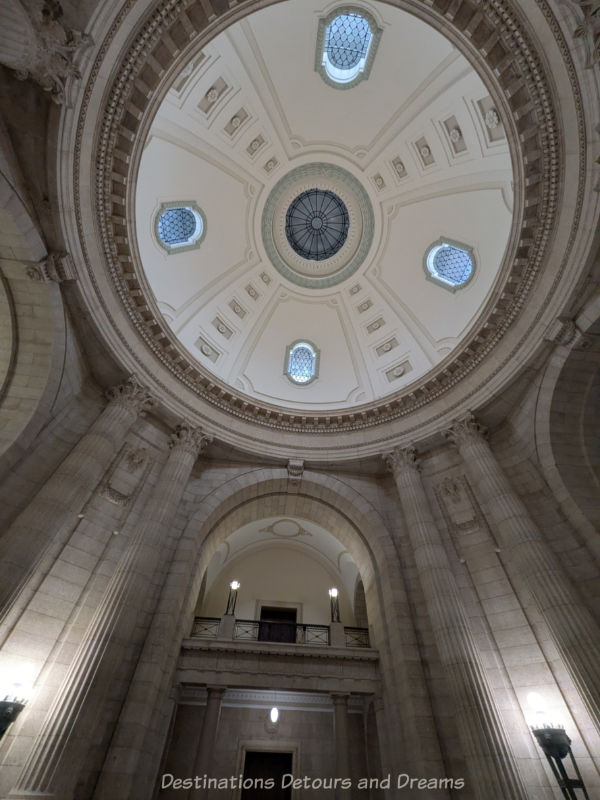 Stone pillars leading up to the decorative white inside of a building dome