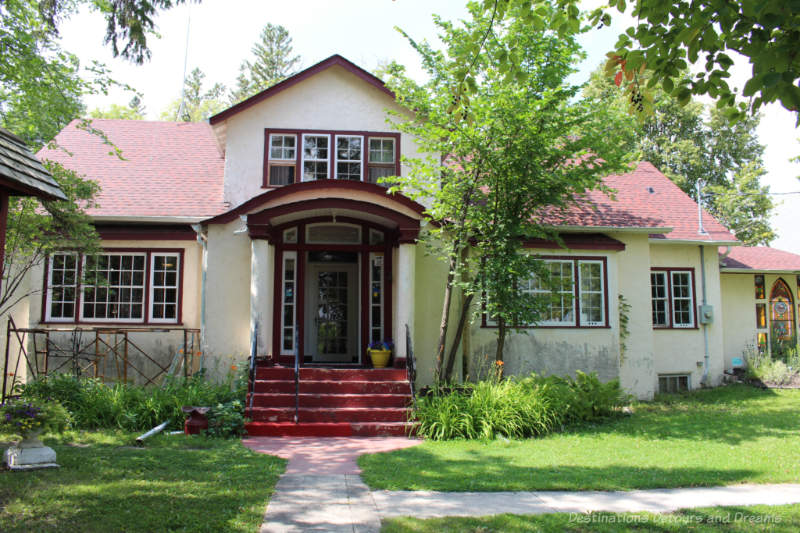 White stucco house with red trim once a rectory and now a museum