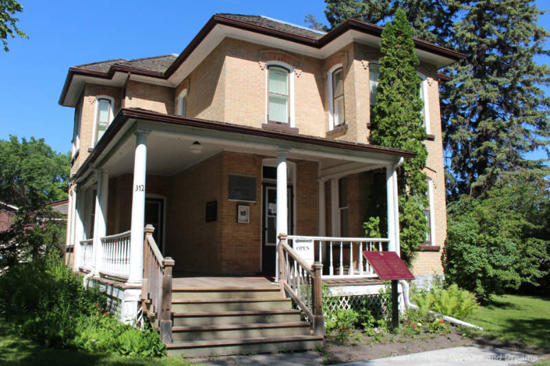 Two story brick house with covered front veranda now a museum