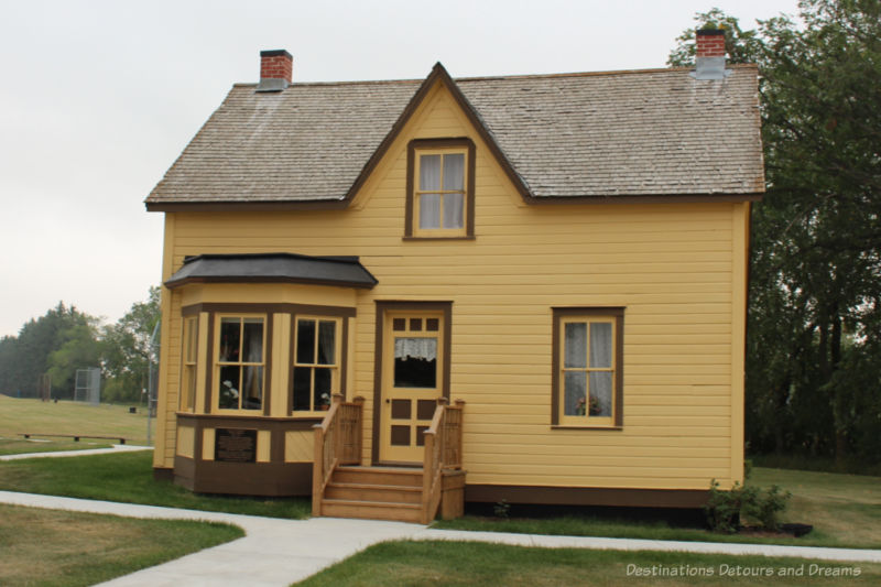 A two-story brownish-yellow house part of the display of Nellie's Homes in Manitoba