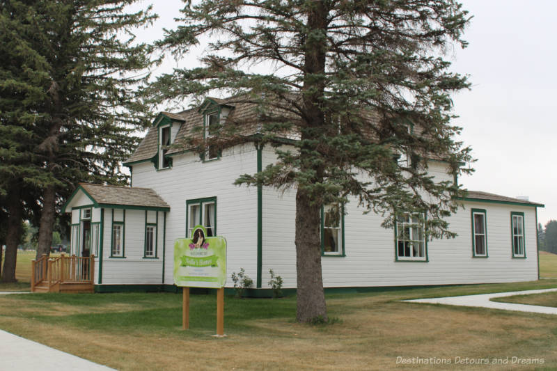 Two story white wooden house with green trim is one of Nellie's Home in Manitou