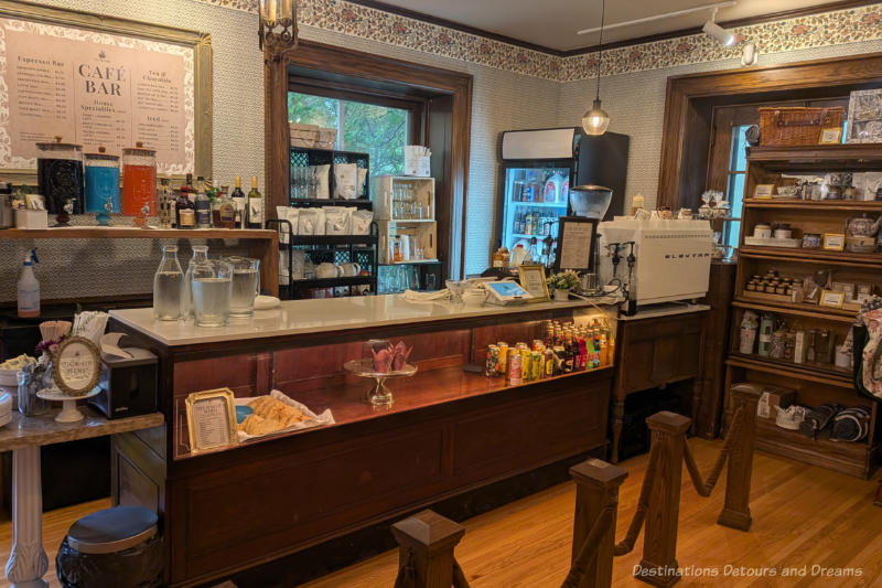 A cafe bar area in an older building featuring wood framed windows and wallpapered walls