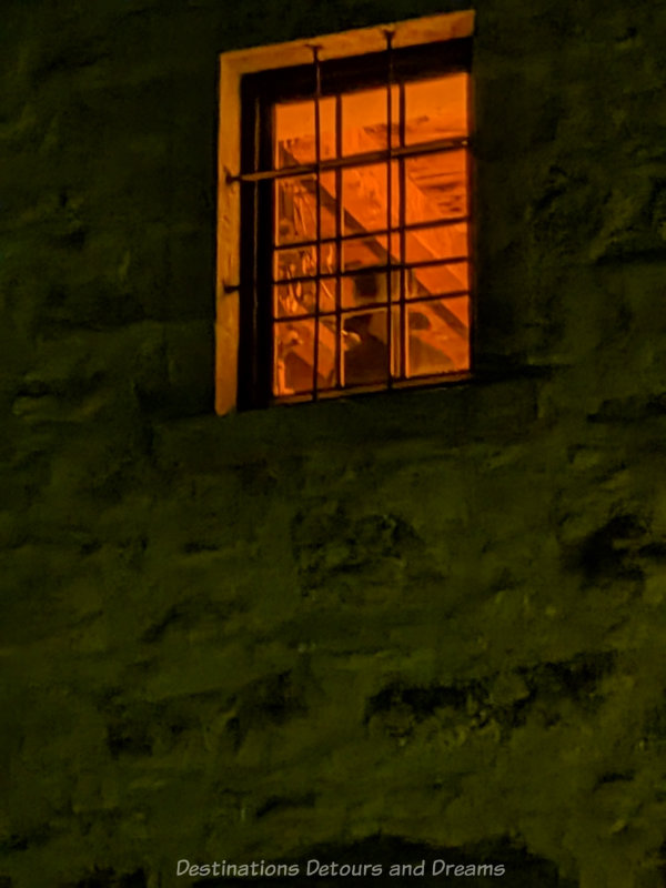 Figure showing in the light of a window on a dark night