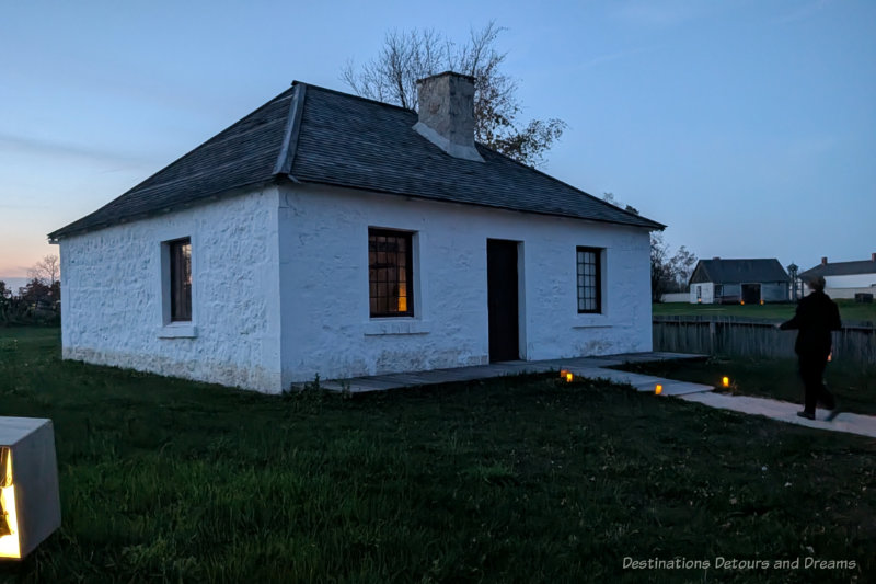 One level stone guest cottage at a 1850s fur trading post attraction at dusk